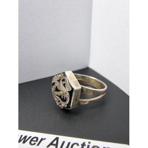 215 - A vintage 925 silver ring with an ornate design featuring overlaid silver on a black base. In good c... 