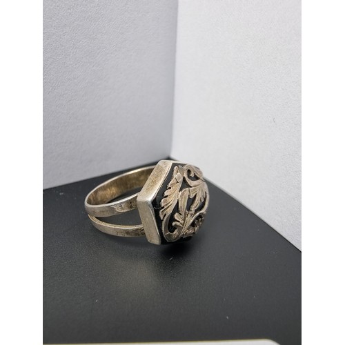 215 - A vintage 925 silver ring with an ornate design featuring overlaid silver on a black base. In good c... 