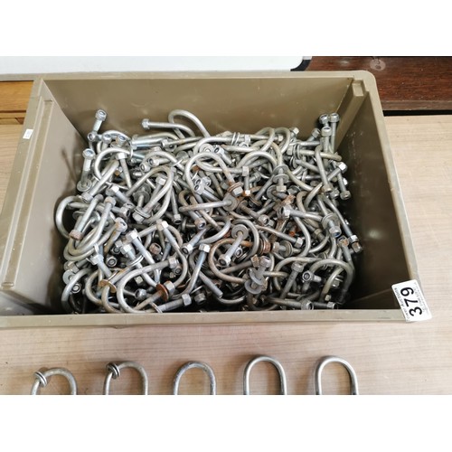 379 - Crate containing a large quantity of exhaust clips each measure 7cm long by 5cm wide