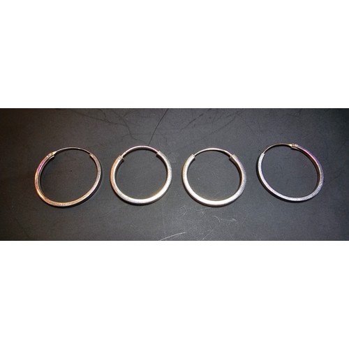 233 - Two pairs of 925 silver hoop earrings of a similar style one pair shinny the other retains its patin... 