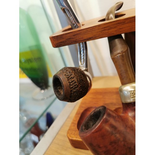 157 - Collection of pipe smoking related collectables in a pipe rack with 4x pipes inc a Petersons pipe, p... 
