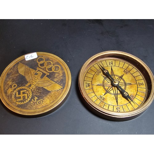 176 - A reproduction Third Reich brass compass with a screw off lid and having Third Reich graphics to the... 