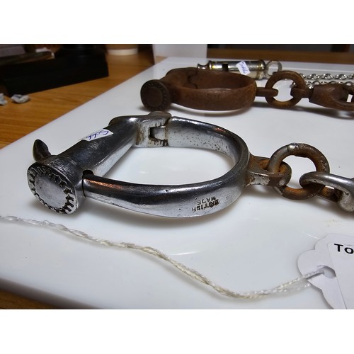 183 - A selection of police related items which includes a pair of vintage chrome handcuffs by Hiatt compl... 