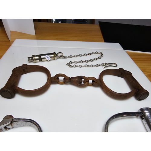 183 - A selection of police related items which includes a pair of vintage chrome handcuffs by Hiatt compl... 