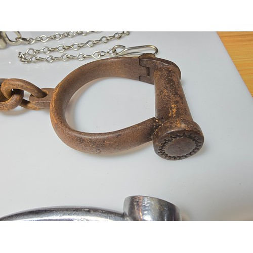 183 - A selection of police related items which includes a pair of vintage chrome handcuffs by Hiatt compl... 