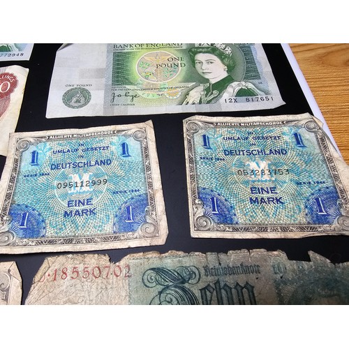 185 - A quantity of German wartime banknotes and coins along with 2 British £1 notes and a 10 shilling not... 