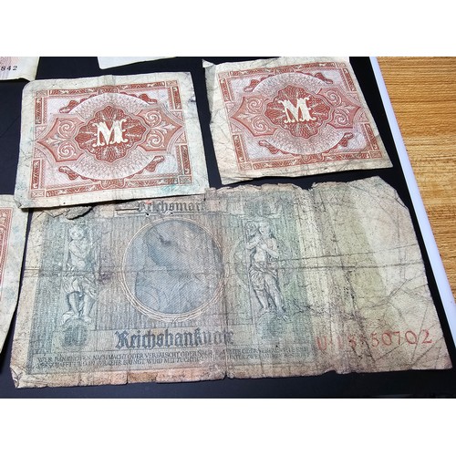 185 - A quantity of German wartime banknotes and coins along with 2 British £1 notes and a 10 shilling not... 