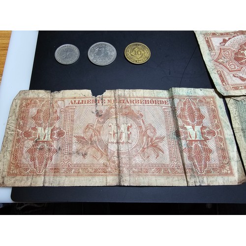 185 - A quantity of German wartime banknotes and coins along with 2 British £1 notes and a 10 shilling not... 