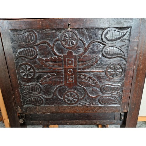 511 - Antique highly carved drinks cabinet with tulip carving to the front and sides, has a pair of pullou... 