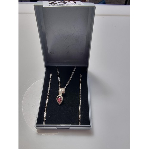 249 - A 925 silver teardrop formed pendant inset with almandine garnet set on an 18