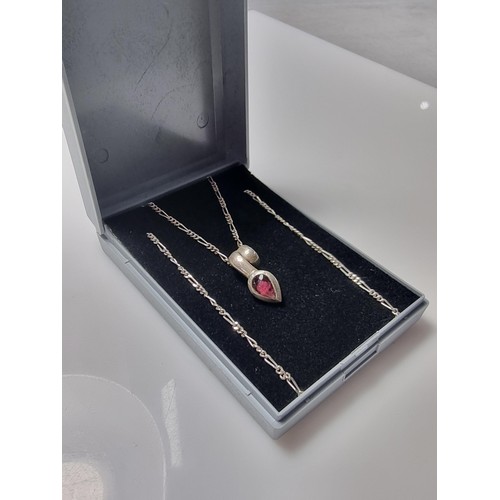 249 - A 925 silver teardrop formed pendant inset with almandine garnet set on an 18