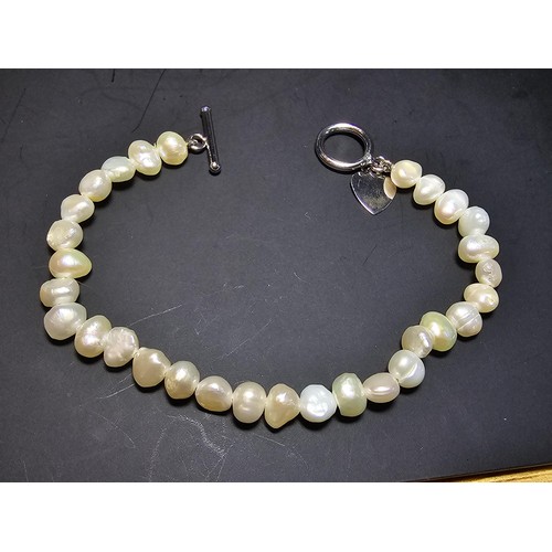 245 - A pretty as new 925 silver and genuine pearl bracelet with a heart charm having a bar and hoop clasp... 