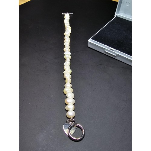 245 - A pretty as new 925 silver and genuine pearl bracelet with a heart charm having a bar and hoop clasp... 