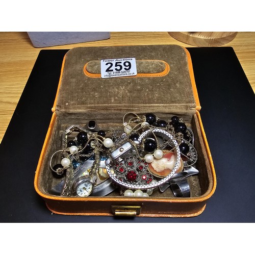 259 - A vintage leather jewellery box containing a quantity of costume jewellery which includes 2 good ver... 