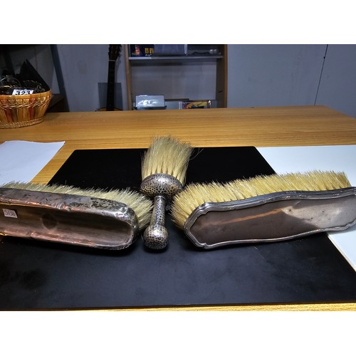 271 - 2x hallmarked silver backed clothes brushes along with a hand hammered white metal handled brush, ap... 