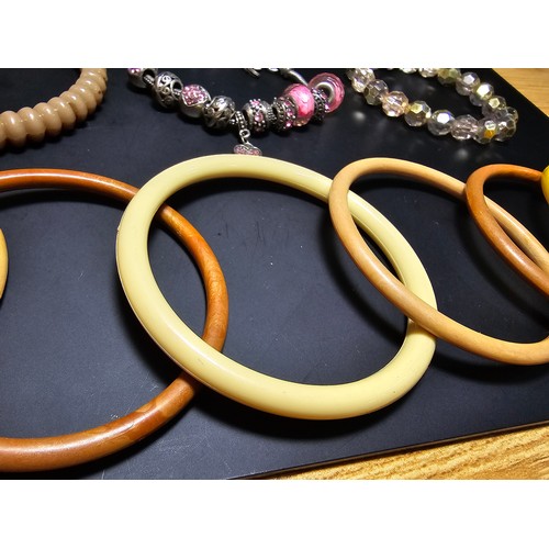 314 - A collection of various vintage bangles and bracelets to include 8 various vintage early plastic ban... 