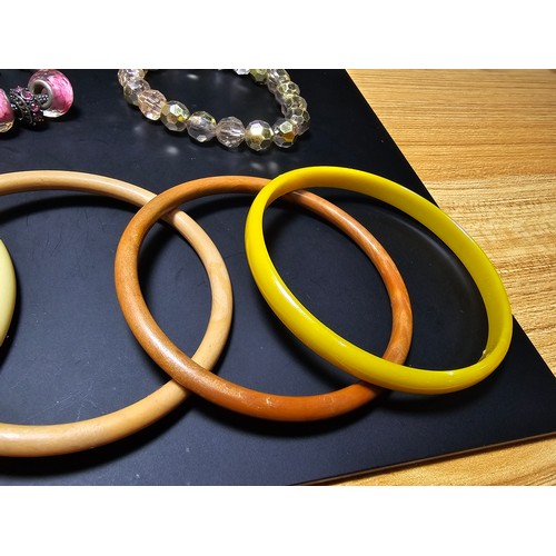 314 - A collection of various vintage bangles and bracelets to include 8 various vintage early plastic ban... 