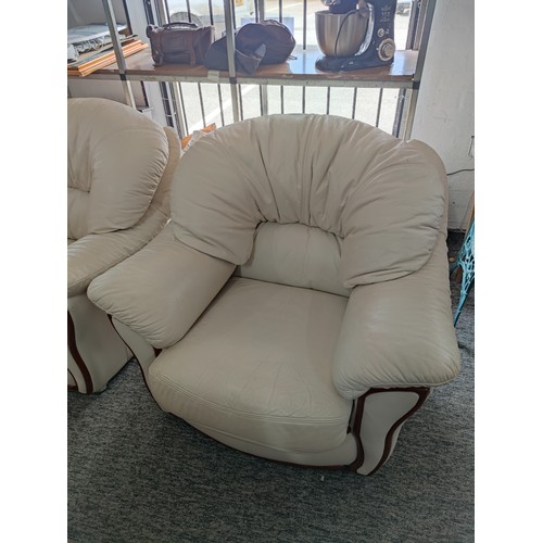 486A - 2x modern cream coloured leather armchairs with wooden accents to the front and in good overall cond... 