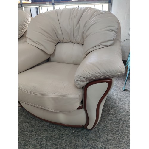 486A - 2x modern cream coloured leather armchairs with wooden accents to the front and in good overall cond... 