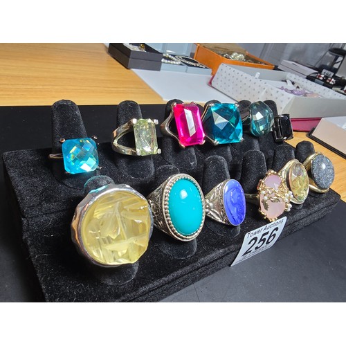 256 - A collection of 12x ornate dress rings, some rings feature large colourful glass stones, 1 ring feat... 