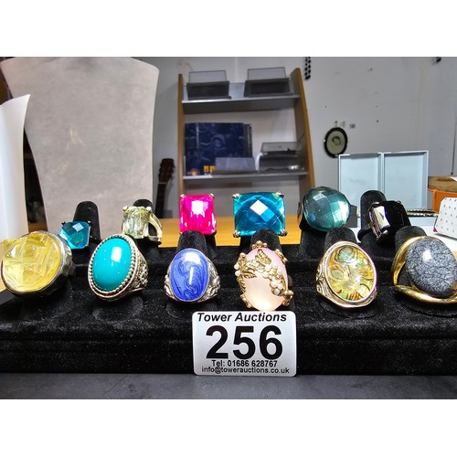 256 - A collection of 12x ornate dress rings, some rings feature large colourful glass stones, 1 ring feat... 