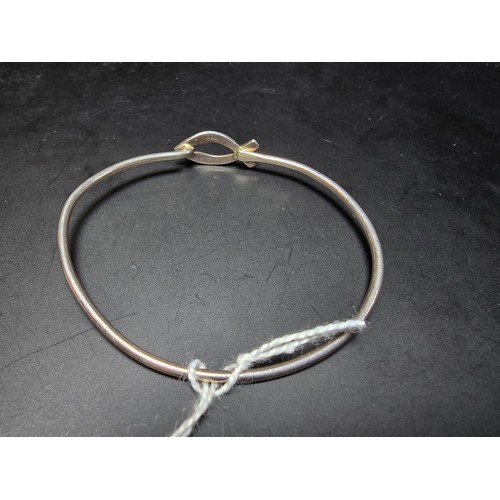 253 - Pretty 925 silver bangle with a fish formed hoop and ball clasp design, in clean condition.