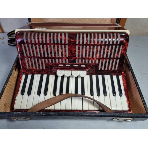 14 - A cased red Weltmeister 48 bass, 4 voice accordion, bellows in good order complete with carrying str... 