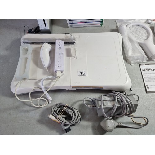 15 - A Nintendo Wii console including controllers (including an as new Wiimote), 7 games, sports racket c... 