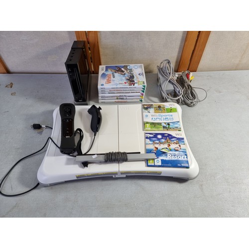 16 - Nintendo Wii console in black with a quantity of Wii Games, Wii Fit board etc