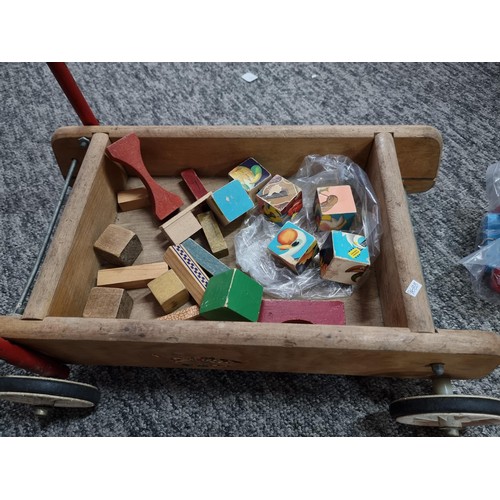 53 - A vintage children's push along trolley along with various children's coloured bricks, pull along to... 