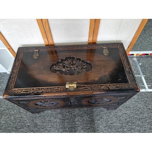 109 - Large Asian Good Quality & Ornate Camphor Wood lidded chest with deep carved decoration to the top o... 