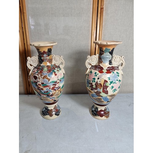 72 - Pair of ornate vases with scroll design to the handles, with oriental designs stands at 39cm high