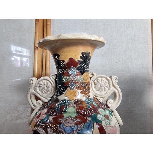 72 - Pair of ornate vases with scroll design to the handles, with oriental designs stands at 39cm high