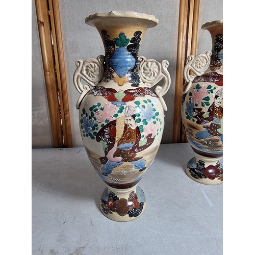 72 - Pair of ornate vases with scroll design to the handles, with oriental designs stands at 39cm high