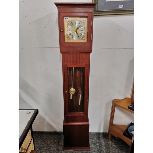 140 - Modern granddaughter quartz clock complete with pendulum, with weights at the back for decoration in... 