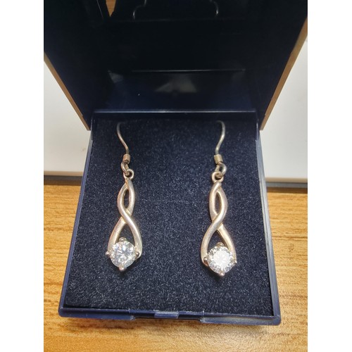 207 - Hallmarked 925 silver figure of 8 shaped drop earrings inset with large CZ stones which are very spa... 