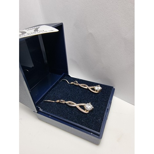 207 - Hallmarked 925 silver figure of 8 shaped drop earrings inset with large CZ stones which are very spa... 