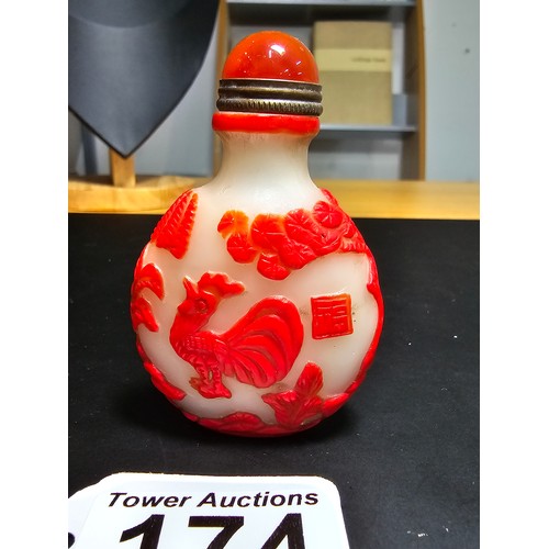 174 - A good vintage carved glass Asian snuff bottle with an agate topped lid with a spoon fitted. The bot... 