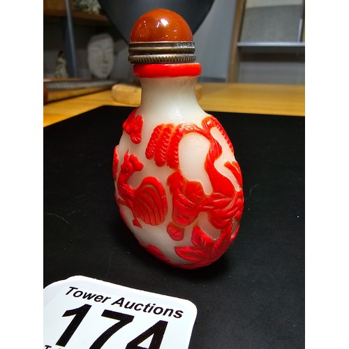 174 - A good vintage carved glass Asian snuff bottle with an agate topped lid with a spoon fitted. The bot... 