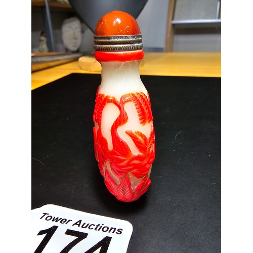 174 - A good vintage carved glass Asian snuff bottle with an agate topped lid with a spoon fitted. The bot... 