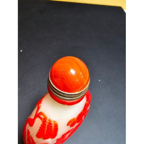 174 - A good vintage carved glass Asian snuff bottle with an agate topped lid with a spoon fitted. The bot... 