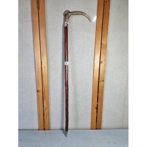 6 - A Black Forest antler formed walking stick, with white metal collar and white metal end in good over... 