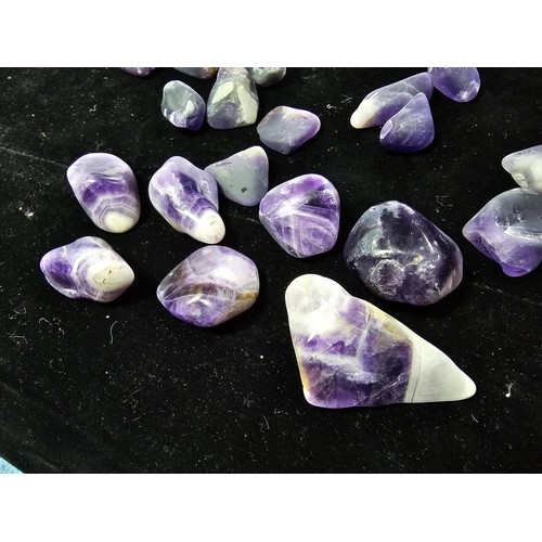 119 - A selection of polished and tumbled amethyst specimens in a glass jar presenting some beautiful indi... 