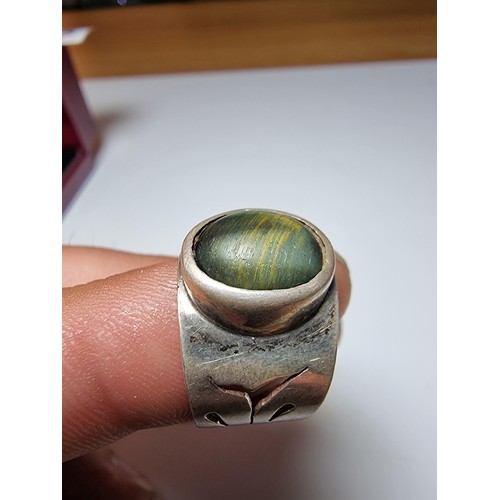 192 - Chunky solid silver dress ring inset with a blue tigers eye stone showing good green and blue flashe... 