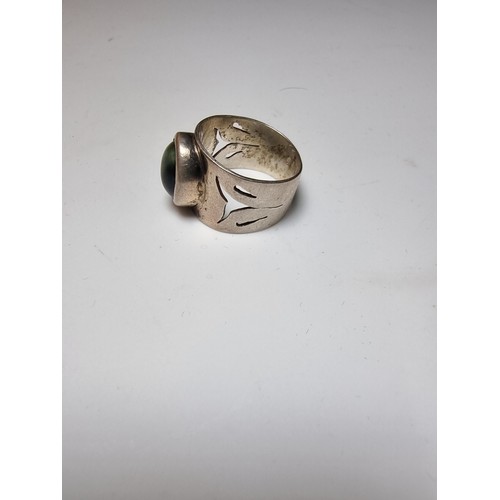 192 - Chunky solid silver dress ring inset with a blue tigers eye stone showing good green and blue flashe... 