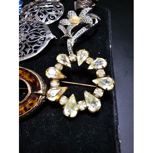 193 - A suite of 11x various pretty vintage brooches to include a gilt filigree red jewelled brooch, an or... 