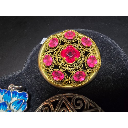 193 - A suite of 11x various pretty vintage brooches to include a gilt filigree red jewelled brooch, an or... 