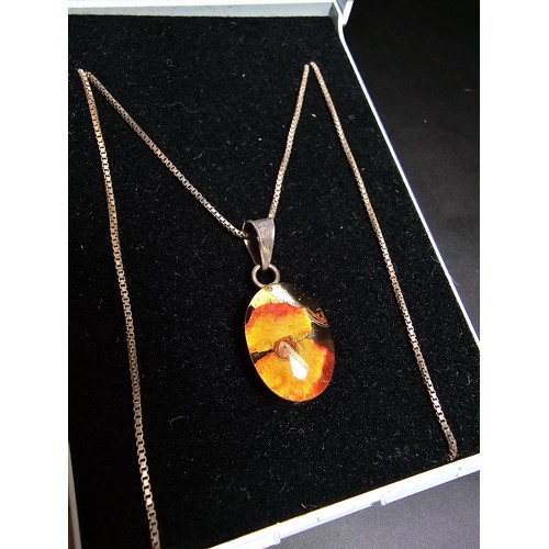 216 - A pretty 925 silver pendant inset with a real dried flower in resin set on an 18