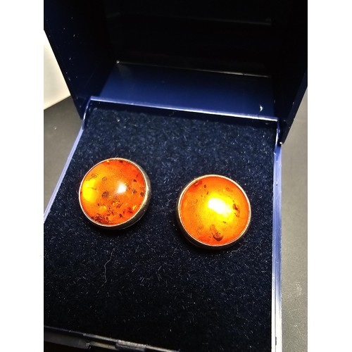 212 - A pair of pretty 925 silver large stud earrings inset with natural Baltic amber stones presenting a ... 