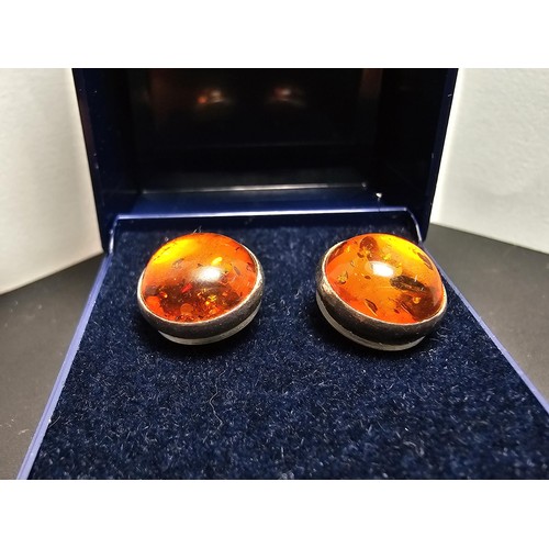212 - A pair of pretty 925 silver large stud earrings inset with natural Baltic amber stones presenting a ... 